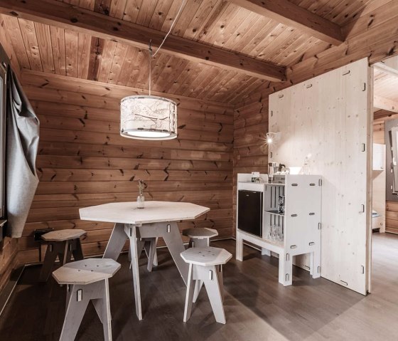 destinature Dorf Blockhuette Essbereich, © destinature destinature Dorf Blockhuette Essbereich, © destinature