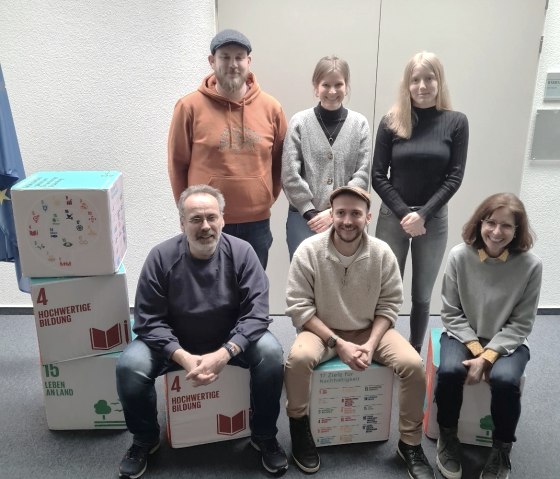 Die Arbeitsgruppe der Naturparke im Foto. Stehend: Hagen Frary (Naturpark Saar-Hunsrück), Meike Schnatz (Naturpark Rhein-Westerwald), Anne Haltenhof (Naturpark Nordeifel). Sitzend: Achim Herf (Natur- und Geopark Vulkaneifel), Bo Manuel Raber (Naturpark Südeifel), Heike Krafft (Naturpark Soonwald-Nahe). , © Natur- und Geopark Vulkaneifel Die Arbeitsgruppe der Naturparke im Foto. Stehend: Hagen Frary (Naturpark Saar-Hunsrück), Meike Schnatz (Naturpark Rhein-Westerwald), Anne Haltenhof (Naturpark Nordeifel). Sitzend: Achim Herf (Natur- und Geopark Vulkaneifel), Bo Manuel Raber (Naturpark Südeifel), Heike Krafft (Naturpark Soonwald-Nahe). , © Natur- und Geopark Vulkaneifel