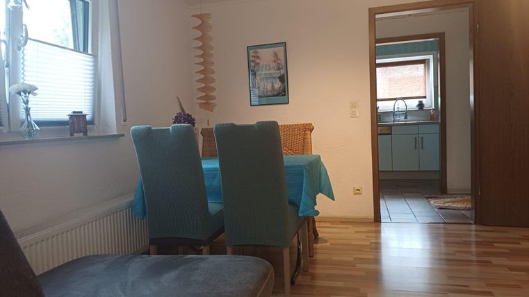 Ein gemütlicher Essbereich mit einem Tisch und Stühlen. Im Hintergrund ist die Küche sichtbar.