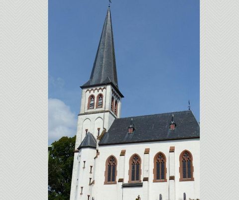Eine beeindruckende Kirche mit einem hohen spitzen Turm. Die Fassade ist hell und hat schöne gotische Fenster.