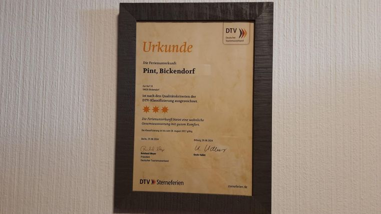 Ein Zertifikat mit dem Titel "Urkunde" für den Platz Bickendorf. Es ist in einem gerahmten Rahmen präsentiert und zeigt eine Bewertung von fünf Sternen.