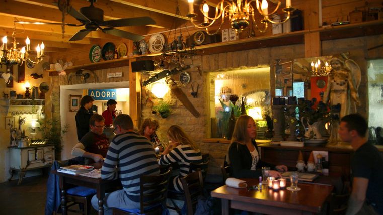 Un restaurant accueillant avec une décoration en bois et une lumière chaleureuse.
Les clients sont assis à des tables et profitent de leur temps dans une atmosphère invitante.