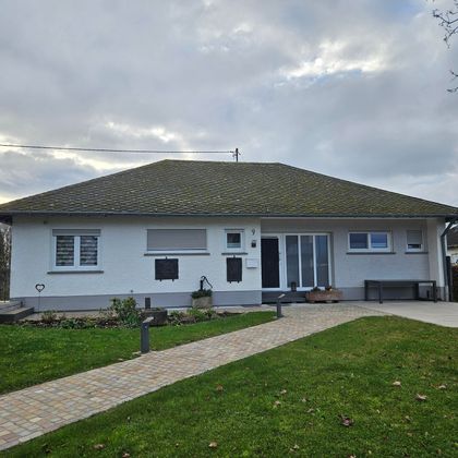 Een modern eengezinswoning met een uitnodigende gevel en een verzorgde tuin. De weg naar de ingang is met stenen geplaveid en omgeven door gazons.