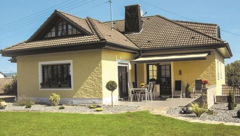 Ein modernes Einfamilienhaus mit gelber Fassade und einem gemütlichen Außenbereich. Der Garten ist gepflegt und lädt zum Entspannen ein.