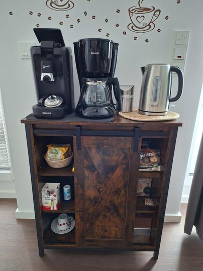 An elegant kitchen shelf with a coffee machine, a drip coffee maker, and a kettle. Below are various utensils and snacks.