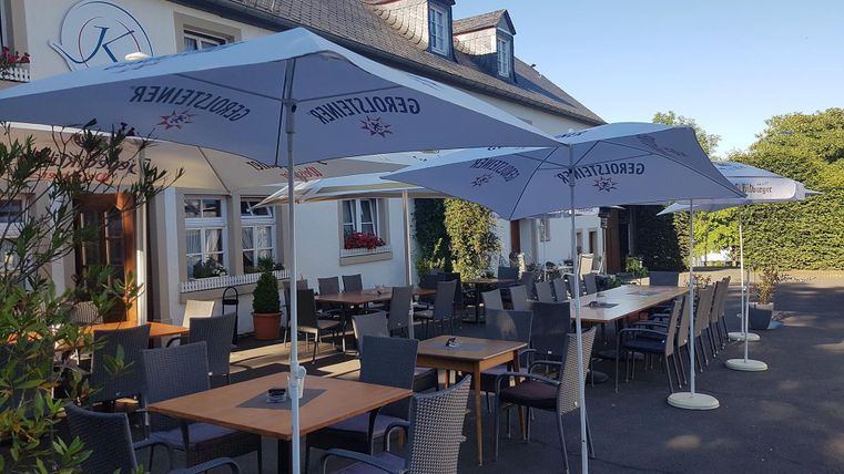 Een uitnodigend restaurant met een buitenterras. Tafels zijn voorzien van parasols en bevinden zich in een rustige omgeving.