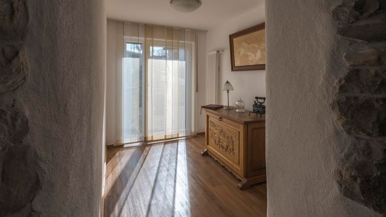 Ein heller Raum mit Holzfußboden und Schränken. Durch große Fenster fällt licht und zeichnet Schatten am Boden.