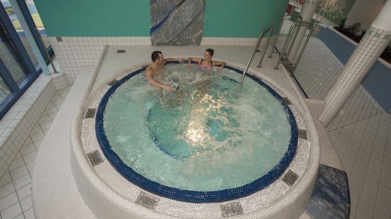 Een whirlpool in een moderne spa-omgeving. Twee personen ontspannen in het water.