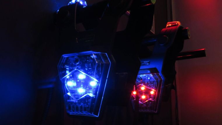 Deux appareils lumineux avec des lumières LED bleues et rouges. Ils sont fixés à un mur et créent une atmosphère futuriste.