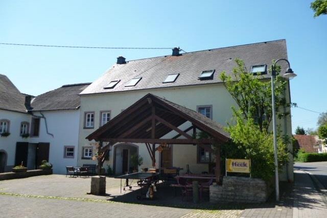 Een gezellig gebouw met een groot portiek in een rustige straat. De omgeving is groen en uitnodigend.