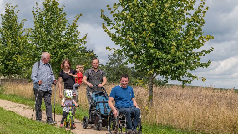 Familie mit Kindern und Rosllstuhlfahrer auf dem barrierefreien Komfortweg in Ammeldingen bei Neuerburg