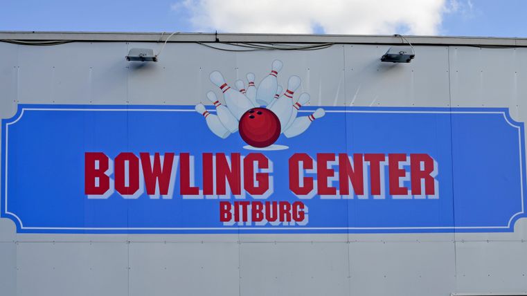 Ein Schild des Bowling Centers in Bitburg. Darauf sind eine Bowlingkugel und Bowlingkegel abgebildet.