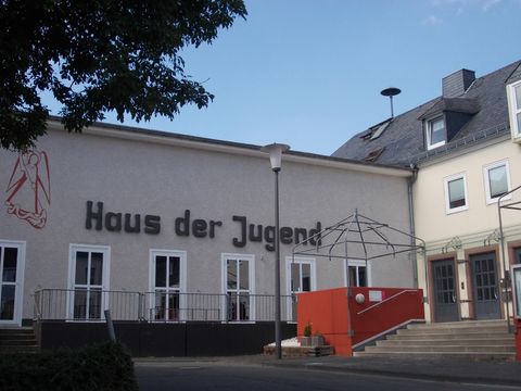 Ein Gebäude mit der Aufschrift "Haus der Jugend". Es ist modern gestaltet und bietet einen einladenden Eingangsbereich.
