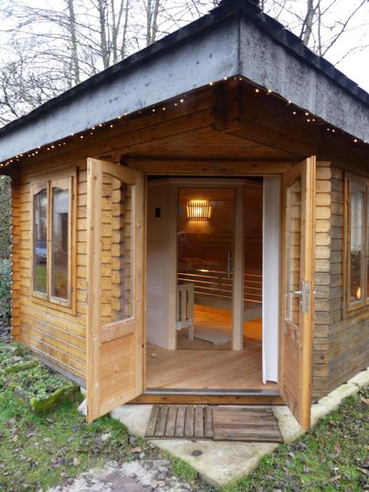 Ein gemütliches Holzhaus mit offenen Türen. Der Innenraum ist gut beleuchtet und einladend.