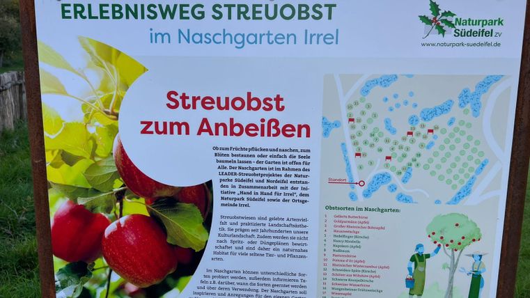 Ein Informationstafel über den Erlebnisweg Streuobst im Naschgarten Irrel. Die Tafel zeigt auch eine Karte des Obstgartens mit verschiedenen Obstsorten zum Pflücken.