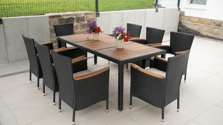 Une élégante table à manger en bois avec huit chaises sur la terrasse pour des après-midis confortables ou des soirées barbecue.