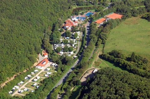 Eine Luftaufnahme eines Campingplatzes mit Stellplätzen für Wohnmobile und Zeltmöglichkeiten. Im Hintergrund sind Grünflächen und ein Schwimmbad sichtbar.