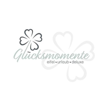Un logo élégant avec l'inscription « Moments de bonheur » et un trèfle. Cela transmet un sentiment d'élégance et de joie de vivre.