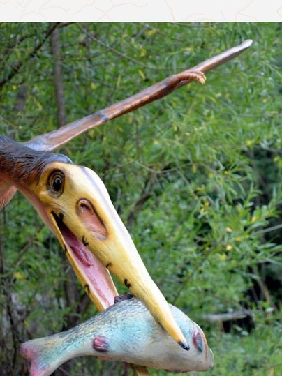 Modell eines Flugsauriers mit einem Fisch im Schnabel im Dinopark.