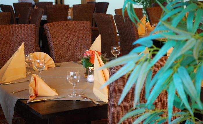 Een elegant restaurant met mooi gedekte tafels. De inrichting is gezellig en zorgvuldig versierd.