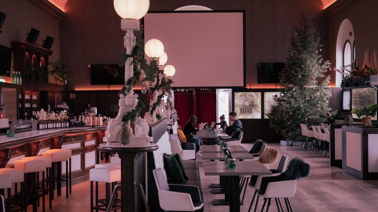 Een stijlvol restaurant met een lange bar en modern interieur. Gezellige tafels en stoelen nodigen uit om te blijven hangen.