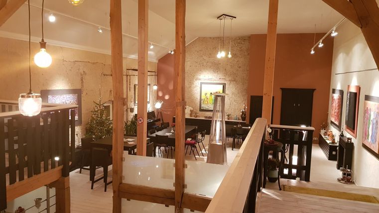 Een stijlvolle, moderne woonkamer met hoge plafonds en houten details. De ruimte is goed verlicht en biedt een gezellige sfeer.