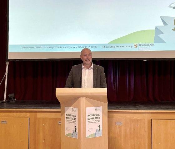 Andreas Kruppert (Verbandsvorsteher Zweckverband Naturpark Südeifel) unterstreicht in seinem Grußwort die wichtige Rolle von Großschutzgebieten bei der Stärkung von Ökosystemen und die daraus resultierende Erhöhung der biologischen Vielfalt., © Naturpark Südeifel/Ansgar Dondelinger