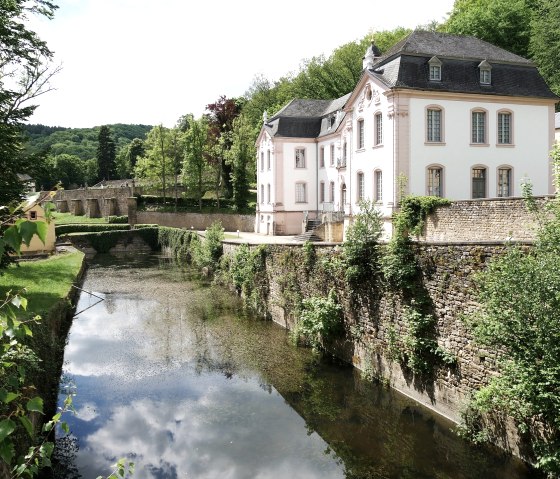 Schloss Weilerbach bei Bollendorf, umgeben von B&auml;umen und einem Wassergraben, unter blauem Himmel mit Wolken., &copy; Elke Wagner, Felsenland S&uuml;deifel Tourismus GmbH