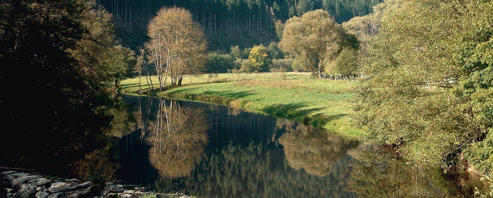 The Our near Obereisenbach, surrounded by autumnal trees and green meadows., © V. Teuschler