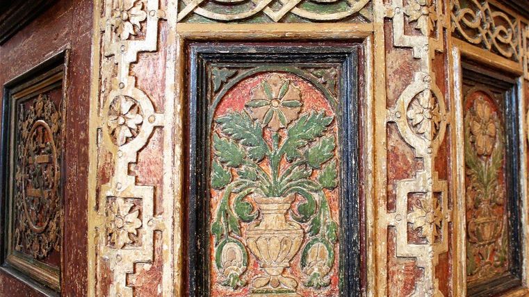 Une construction en bois habilement conçue avec des reliefs colorés de plantes et de motifs géométriques. Les ornements sont riches en détails et témoignent d'un savoir-faire historique.