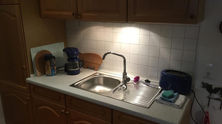 Eine kleine Küche mit allen wichtigen Elektrogeräten (Kühlschrank, E-Herd mit Backofen, Mikrowelle, Kaffeemaschine, Wasserkocher, Toaster) und einer gemütlichen Essecke. .