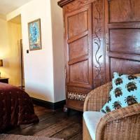 Een gezellige kamer met een houten kast en een rotan stoel. Het is warm en uitnodigend met een rustieke charme.