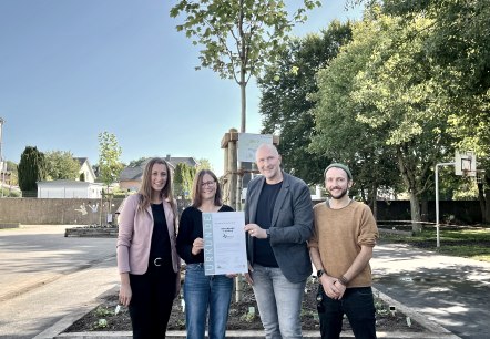 Freuen sich mit den Kindern &uuml;ber die Zertifizierung (von links): Janine Fischer (B&uuml;rgermeisterin Verbandsgemeinde Bitburger Land), Dorothee Heser (Schulleiterin Grundschule Wolsfeld), Andreas Kruppert (Verbandsvorsteher Zweckverband Naturpark S&uuml;deifel) und Bo Raber (Fachkraft Zweckverband Naturpark S&uuml;deifel). , &copy; Naturpark S&uuml;deifel/Ansgar Dondelinger