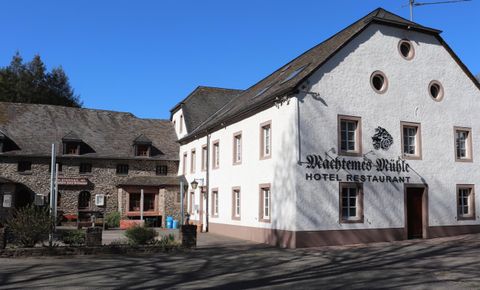 Ein charmantes Hotel und Restaurant mit einer weißen Fassade. Die Umgebung ist ruhig und einladend.