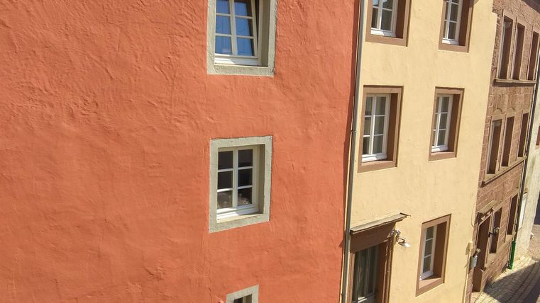 Kleurige gevels in een rustige straat. De gebouwen zijn licht en uitnodigend.