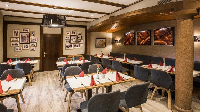 Ein modernes Restaurant mit komfortablen Tischen und Stühlen. Die Wände sind geschmückt mit Bildern und die Tische sind schön dekoriert.