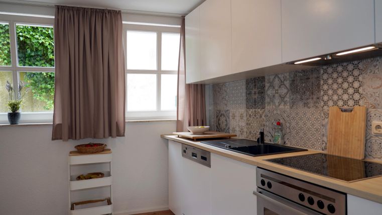 Een lichte keuken met moderne meubels en een groot werkblad.