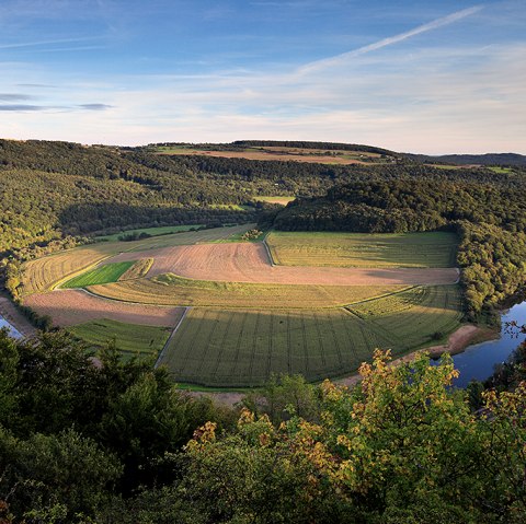 Panoramablick auf eine Flusslandschaft mit Feldern und Wäldern im warmen Licht der untergehenden Sonne., © Naturpark Südeifel, C. Schleder