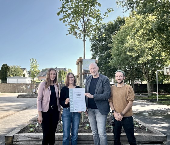 Freuen sich mit den Kindern über die Zertifizierung (von links): Janine Fischer (Bürgermeisterin Verbandsgemeinde Bitburger Land), Dorothee Heser (Schulleiterin Grundschule Wolsfeld), Andreas Kruppert (Verbandsvorsteher Zweckverband Naturpark Südeifel) und Bo Raber (Fachkraft Zweckverband Naturpark Südeifel). , © Naturpark Südeifel/Ansgar Dondelinger