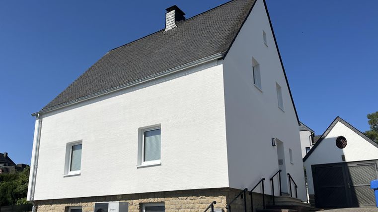 Vue de façade de la maison de vacances avec un escalier en maçonnerie menant à l'entrée.