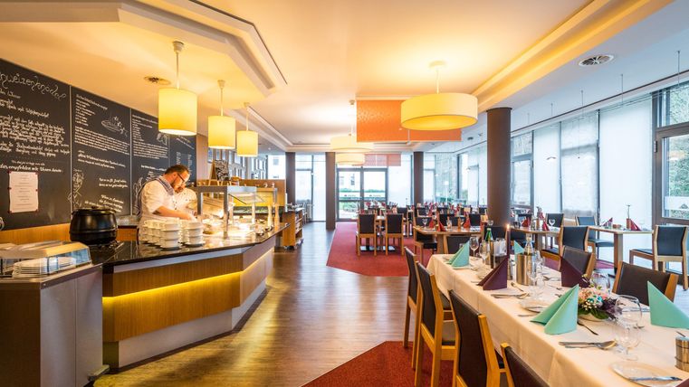 Een modern restaurant met een gezellige sfeer. Het gebied is helder verlicht en biedt een aantrekkelijk gedekte tafel.