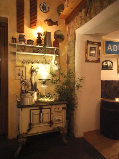 Une vue intérieure confortable avec une armoire rustique et des objets décoratifs. La lumière chaleureuse crée une atmosphère accueillante.