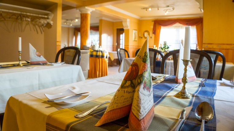 Une table joliment dressée dans un restaurant élégant. La décoration de la table se compose de serviettes pliées et de bougies.