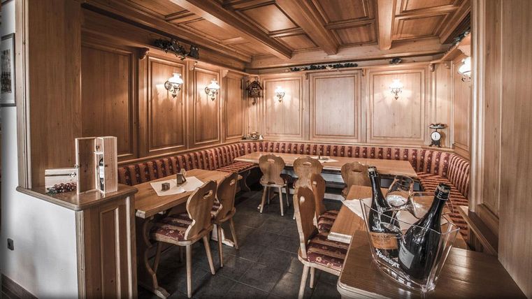 Un restaurant chaleureux avec des revêtements en bois et des sièges confortables. L'éclairage crée une atmosphère accueillante.