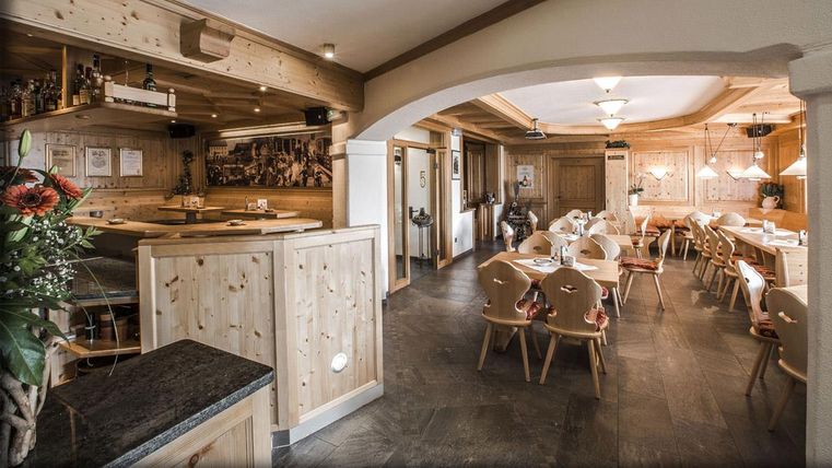 Un restaurant confortable avec des meubles en bois et une lumière chaleureuse. Les tables sont préparées pour les clients et transmettent une atmosphère accueillante.