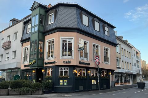 Een charmant restaurant met een bijzonder architectuurontwerp. Het bevindt zich op een straathoek en heeft grote ramen met uitzicht op de straat.